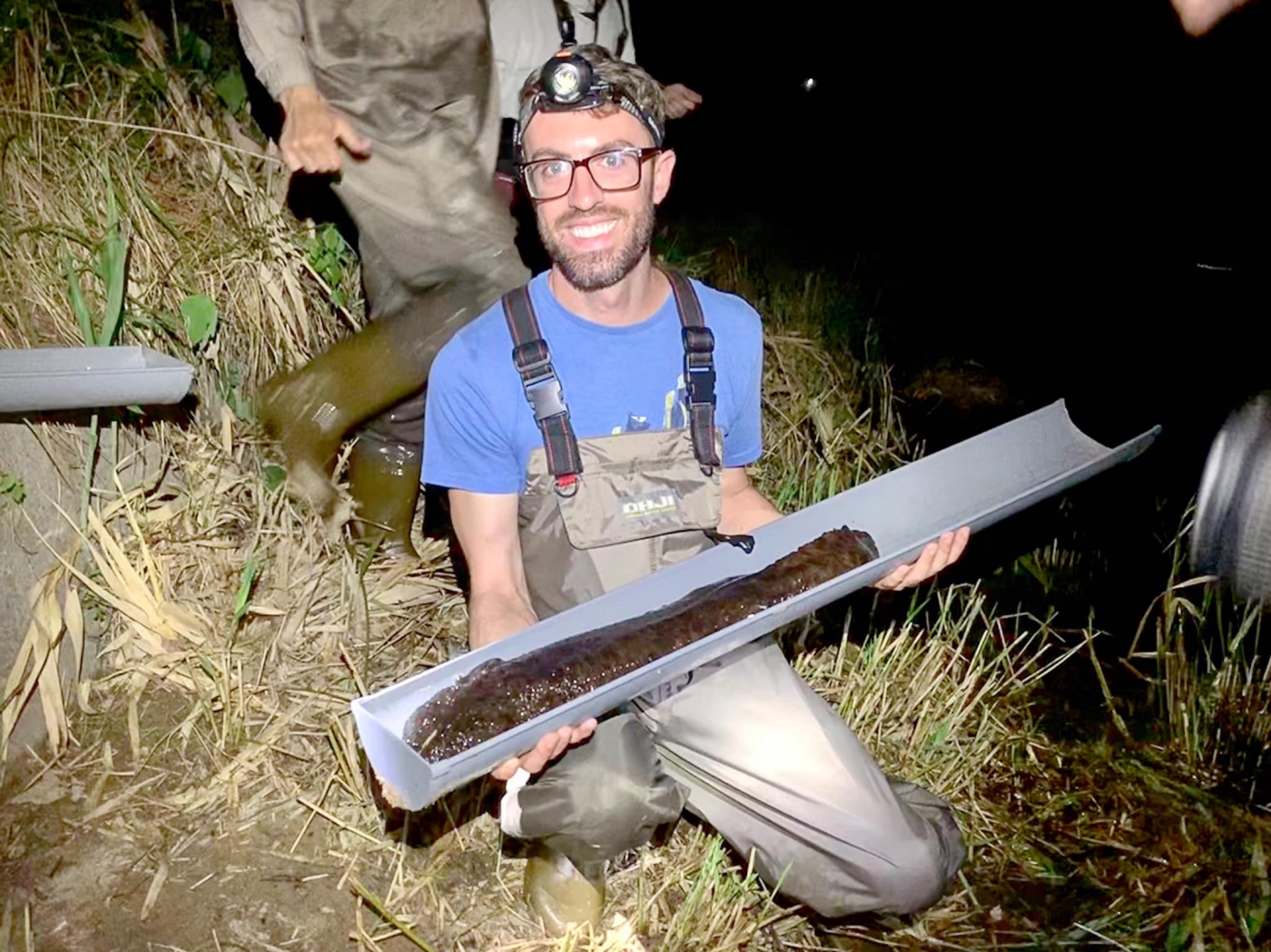 Reptile Discovery Center keeper Matt Neff with a wild Japanese giant salamander in Hiroshima, Japan.