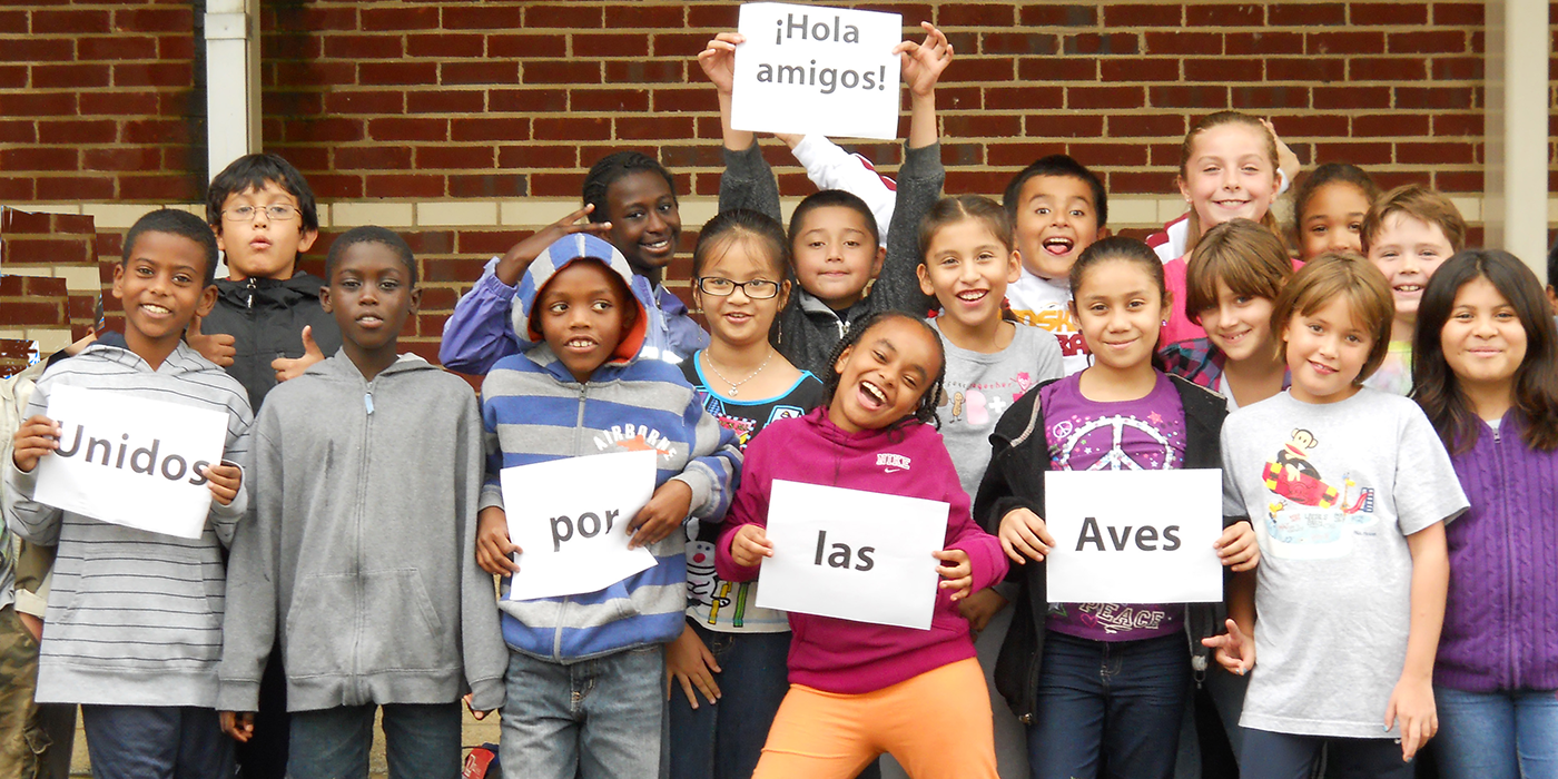 a group of children hold up signs that say "unidos por las aves"