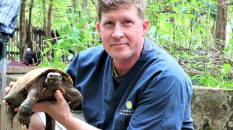 Matt Evans holding a turtle at a facility in Myanmar. 