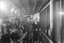 First Lady Patricia Nixon at the Zoo on April 20, 1972, for the official welcome ceremony for giant pandas Ling-Ling and Hsing-Hsing, a gift from China to the American people. The panda pair first arrived at the Zoo on Sunday, April 16, 1972. Photo courtesy of the Richard Nixon Presidential Library Journalists stand in a crowd and photograph giant pandas; First Lady Patricia Nixon stands in front of them outside the indoor giant panda habitat
