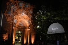 Orange spider web projection on outdoors of Reptile Discovery Center. 