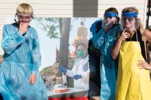 Students pose wearing protective clothing that scientists studying zoonotic diseases wear when collecting samples in the field. Students posing wearing protective clothing wildlife scientists studying zoonotic diseases wear in the field.